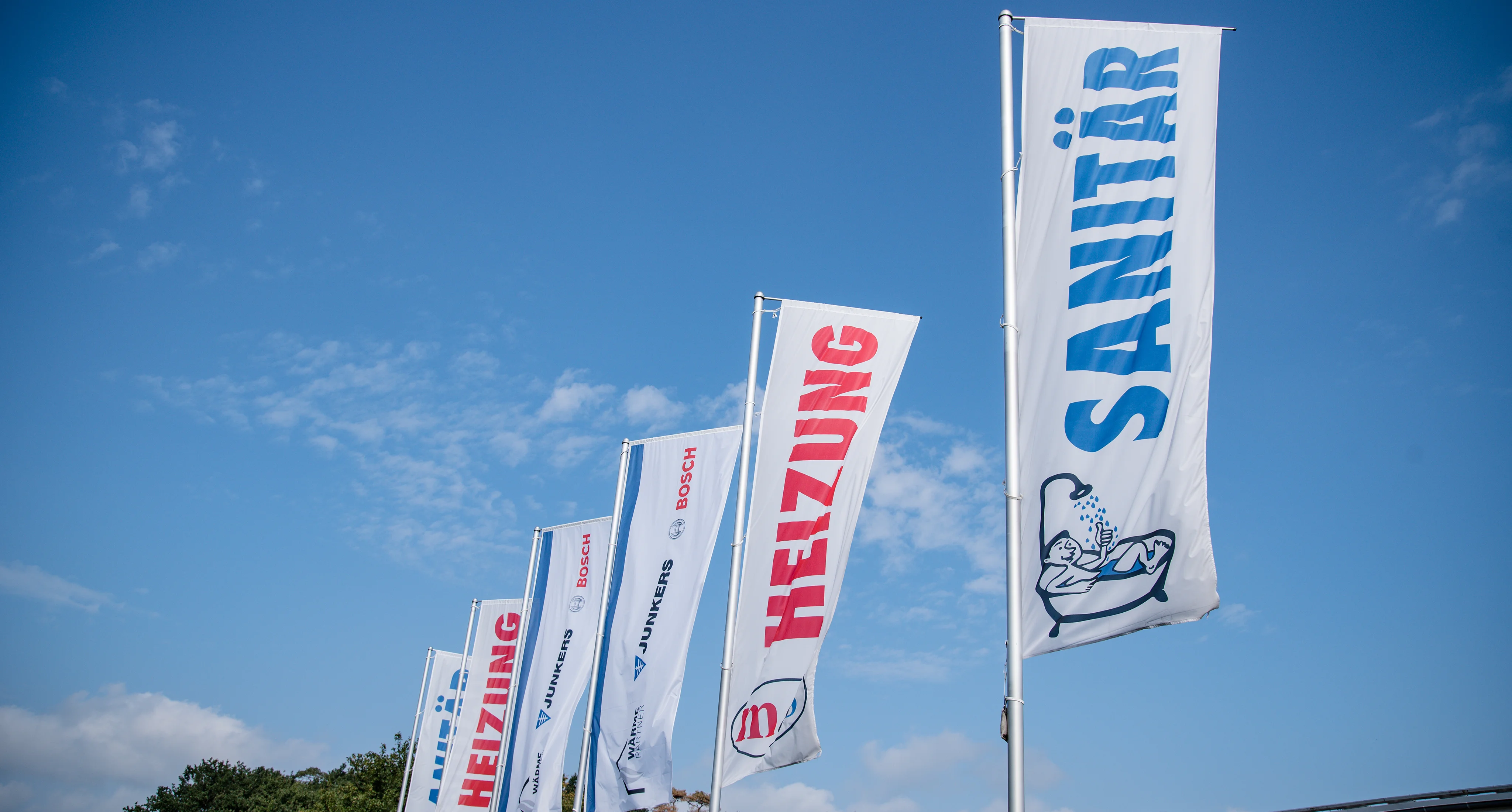 Mehrere Fahnen bei gutem Wetter auf dem Firmengeländ von M&S in Lohne