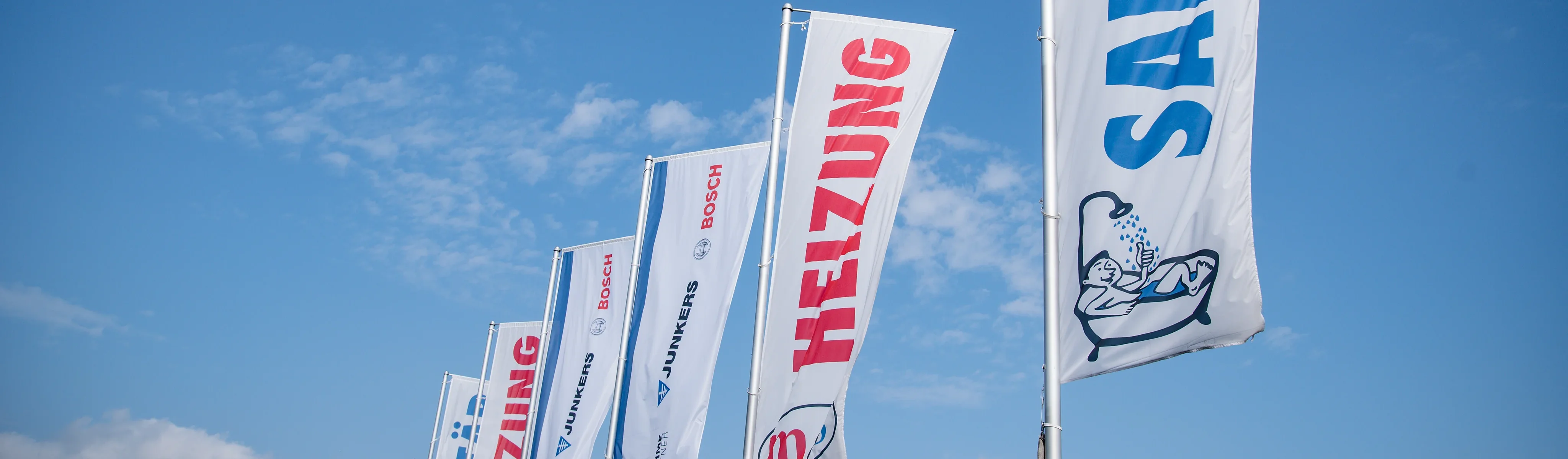 Mehrere Fahnen bei gutem Wetter auf dem Firmengeländ von M&S in Lohne